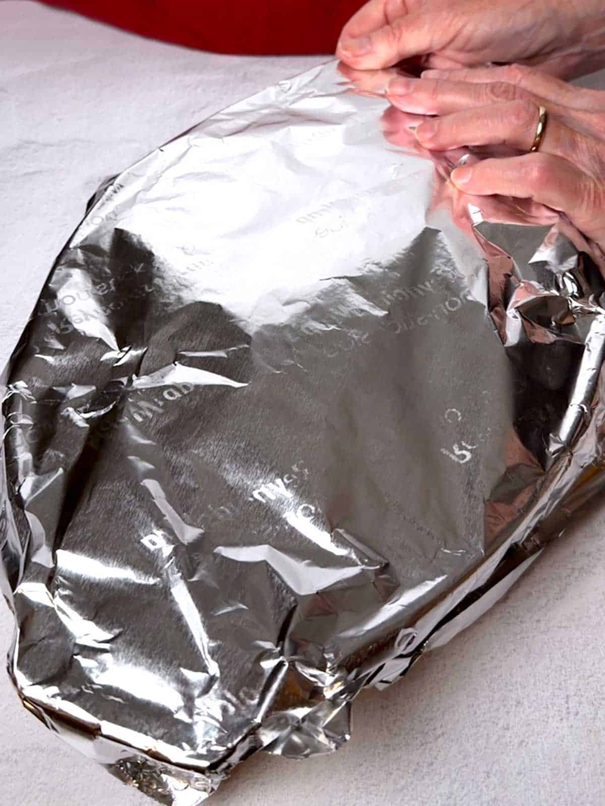 Covering the casserole dish with alumimum foil.