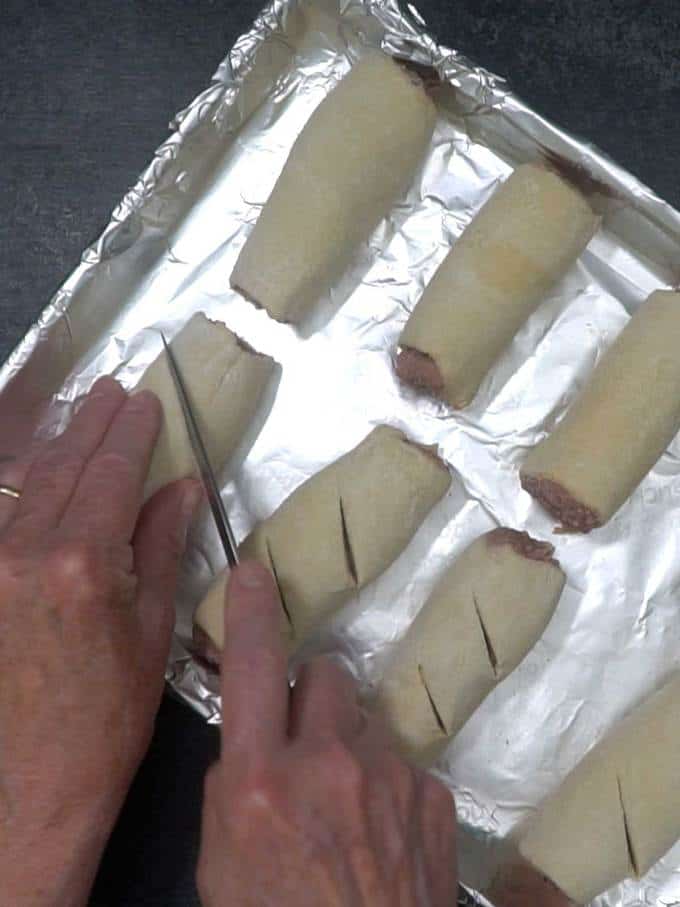 Cutting slits in sausage rolls