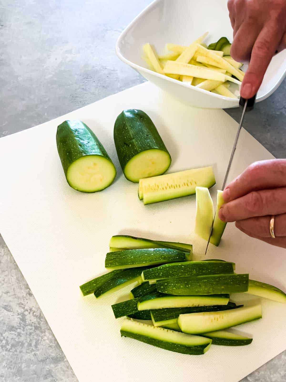 Cutting zucchini into sticks and cutting away the seeds
