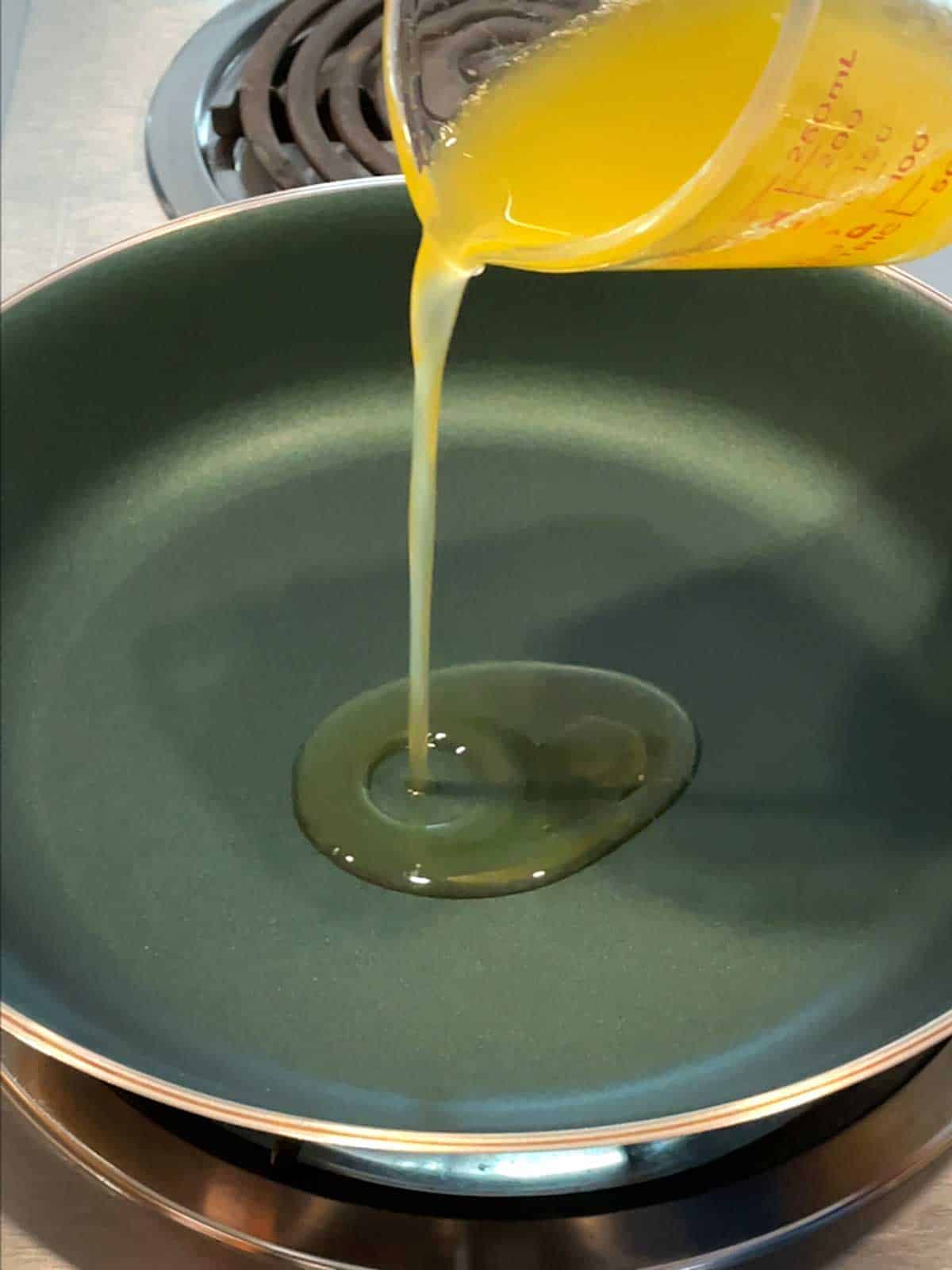 Adding clarified butter to skillet.
