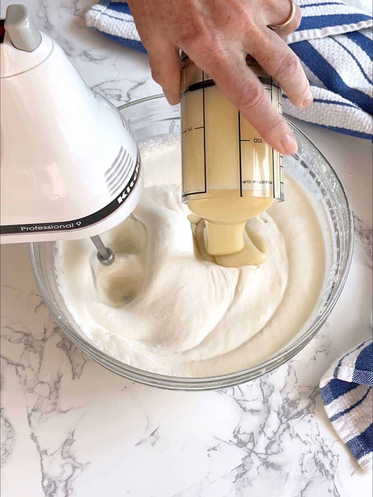 Adding sweetened condensed milk to the whipped cream.
