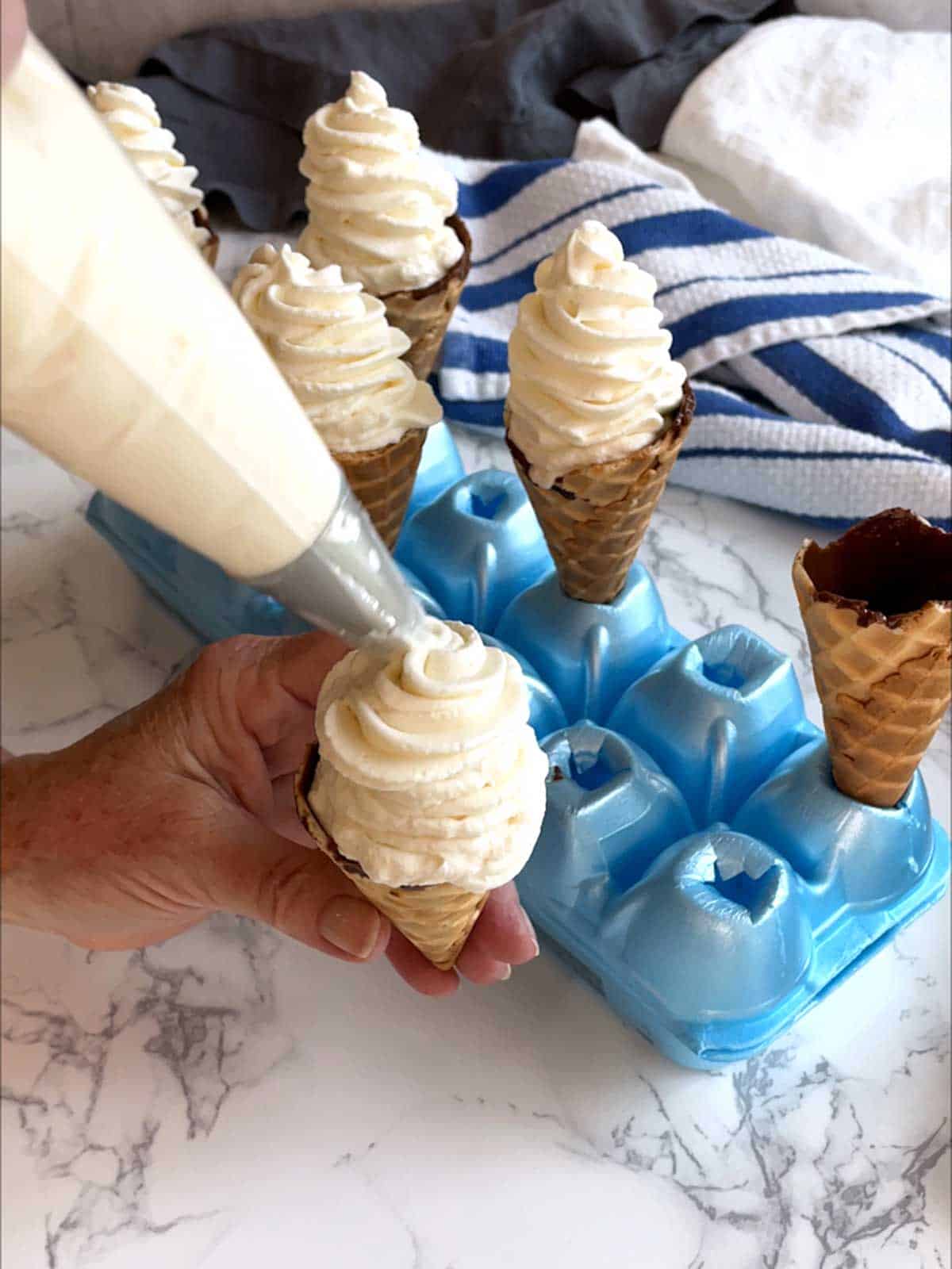 Piping the ice cream into the coated cones.