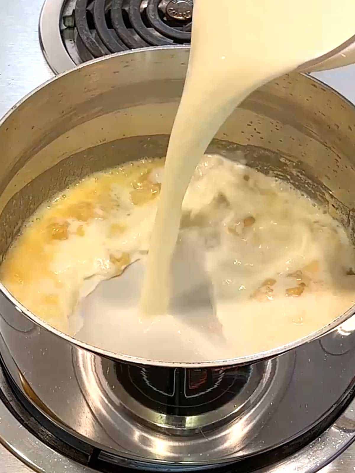 Adding milk to roux.