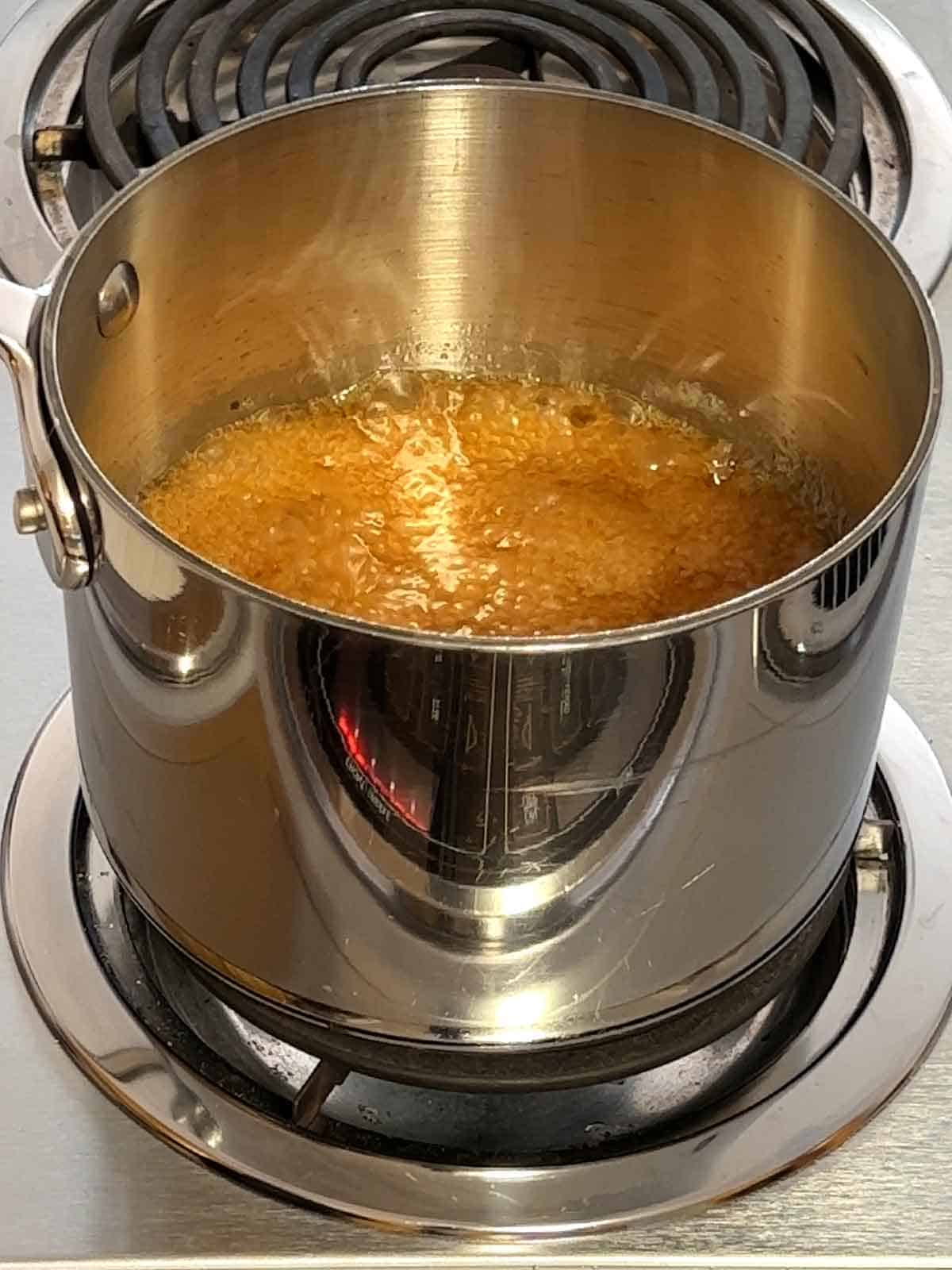 Boiling the caramel mixture over medium-low heat.