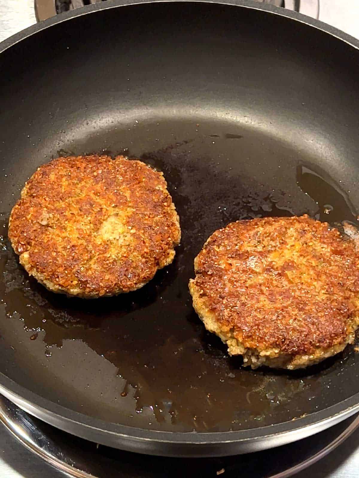 Cooking the patties in a skillet over medium heat.