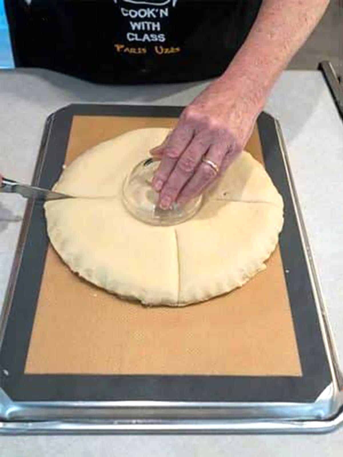 Making four cuts in dough.