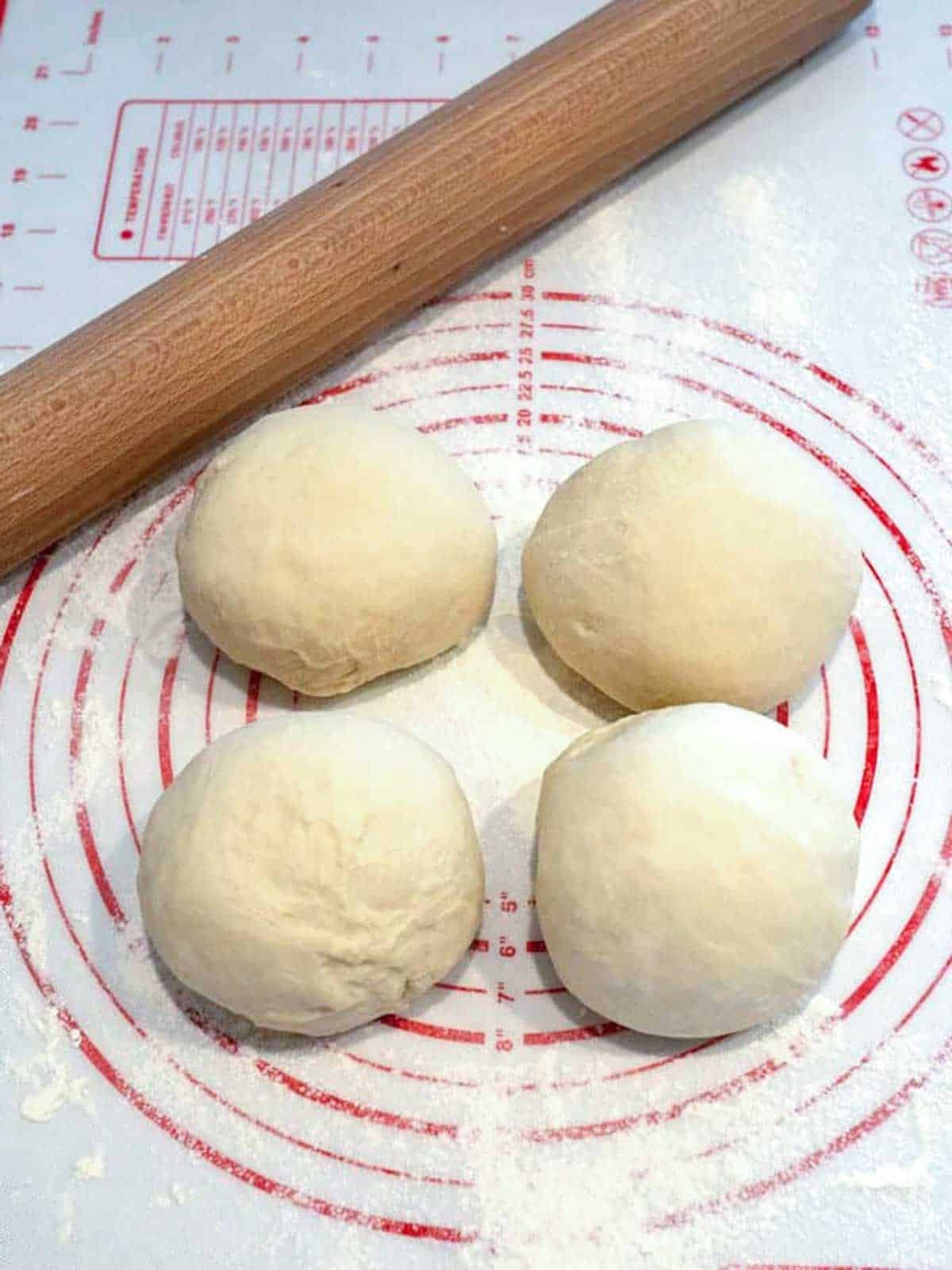 Dough balls on a floured surface.