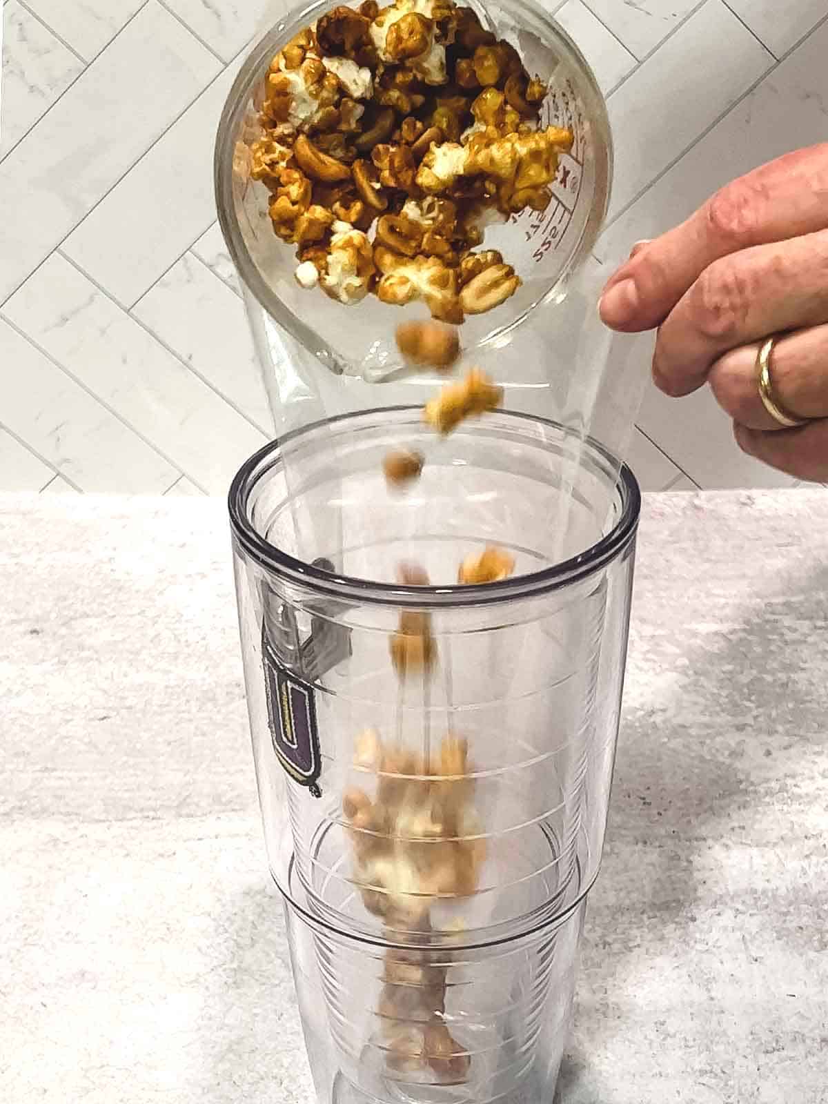 Adding the caramel corn to cone-shaped treat bag.