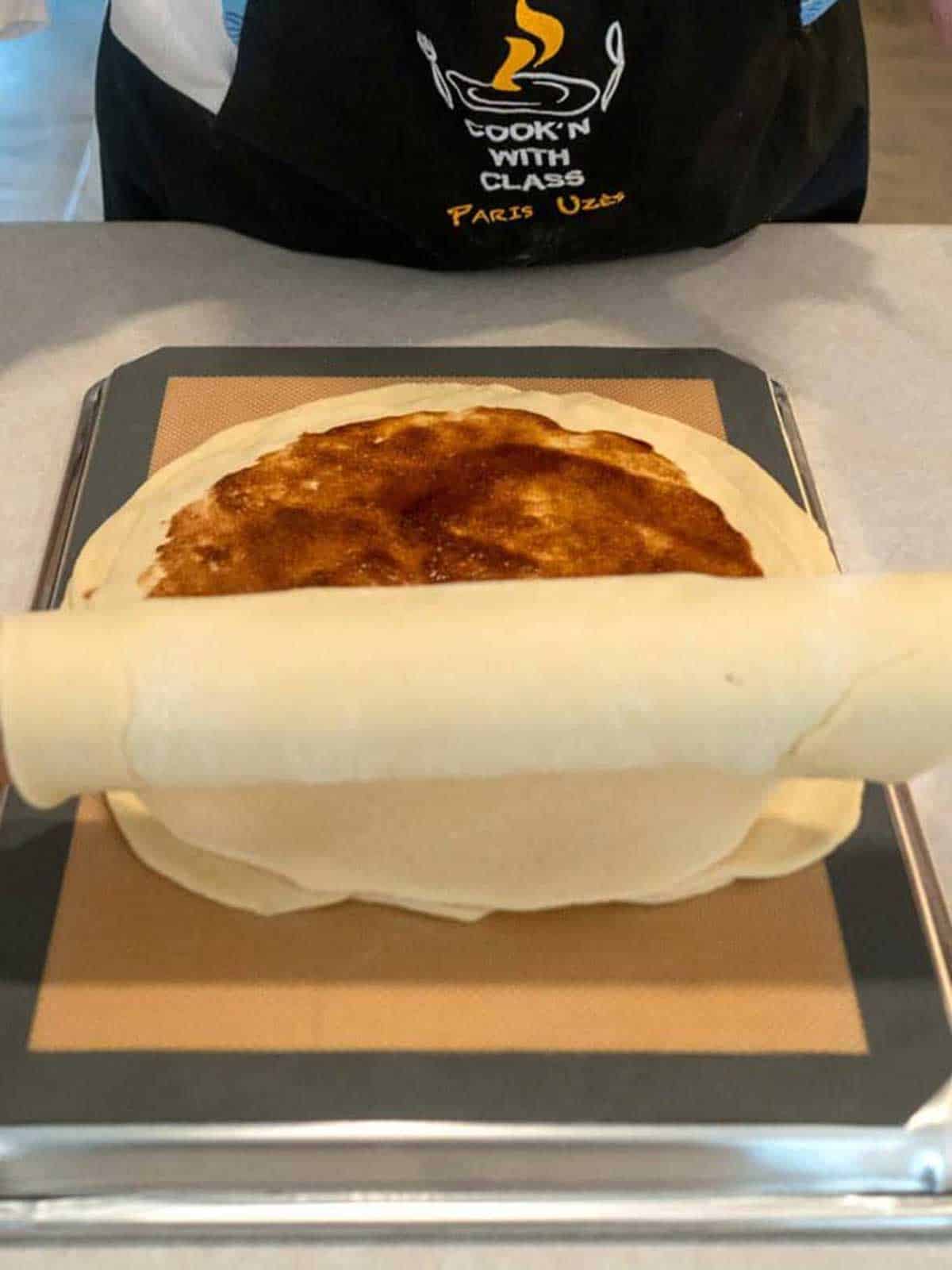 Placing the final piece of dough on the stack.