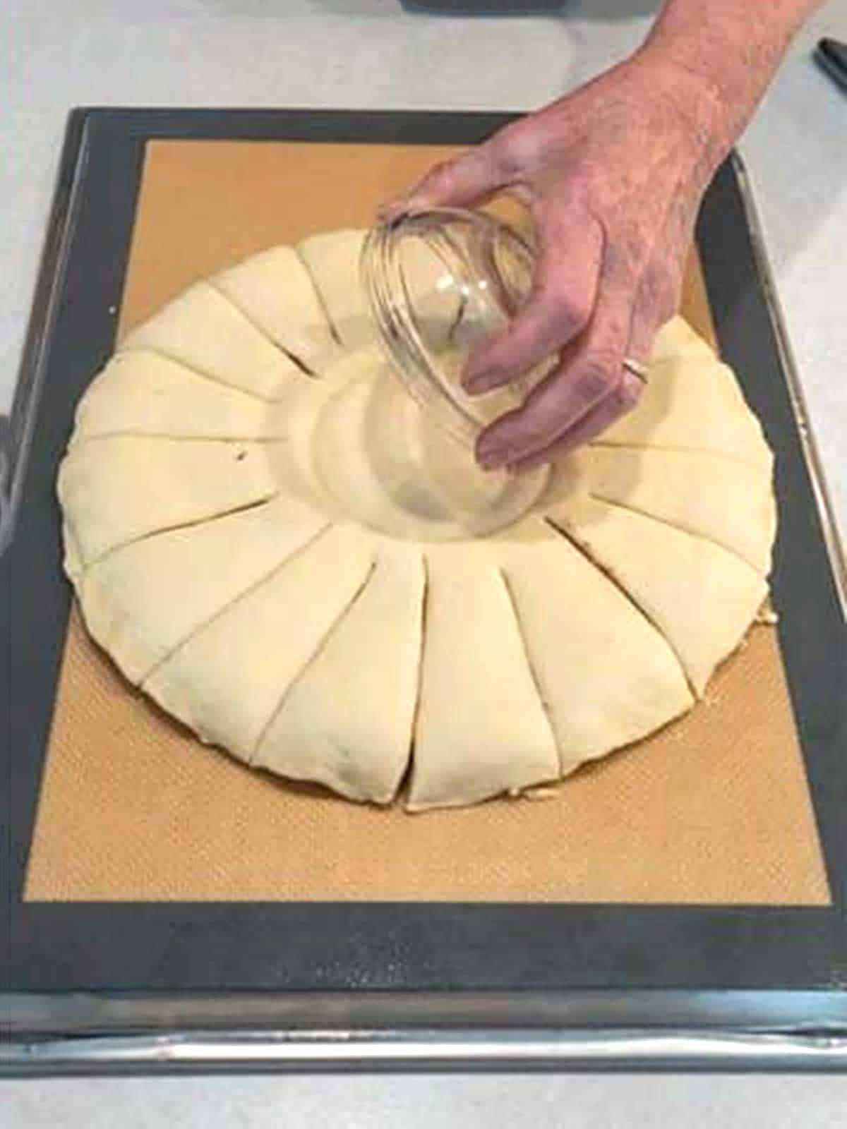 Removing the bowl from the dough that has been cut into 16 wedges.
