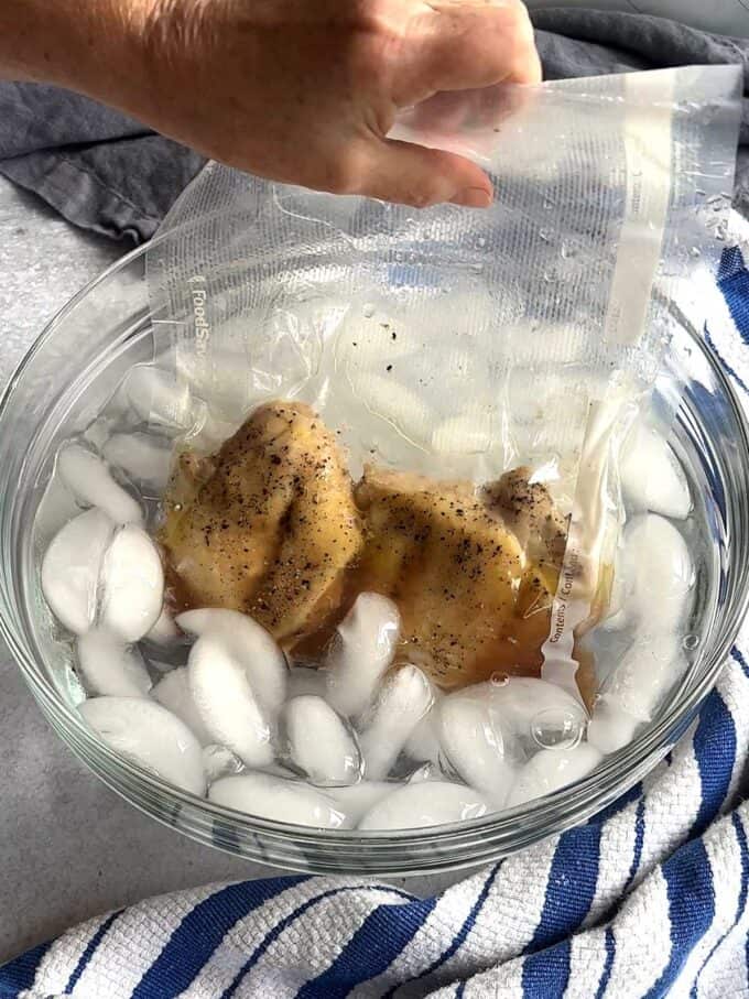Placing cooked chicken in ice water bath to cool down.