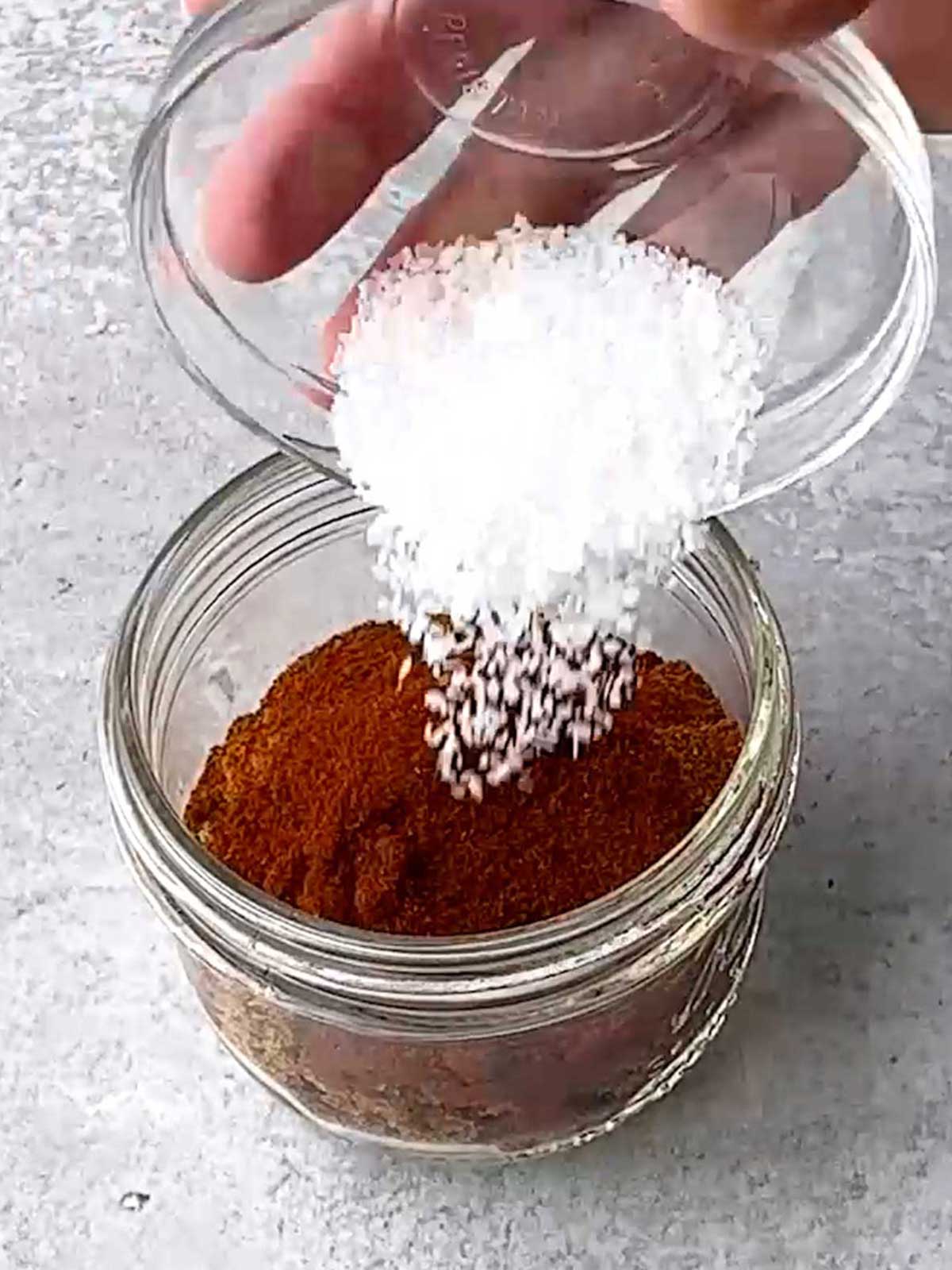 Adding salt to the dry rub ingredients.