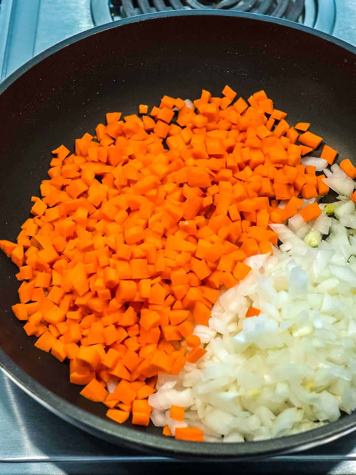Onions and carrots in a skillet.