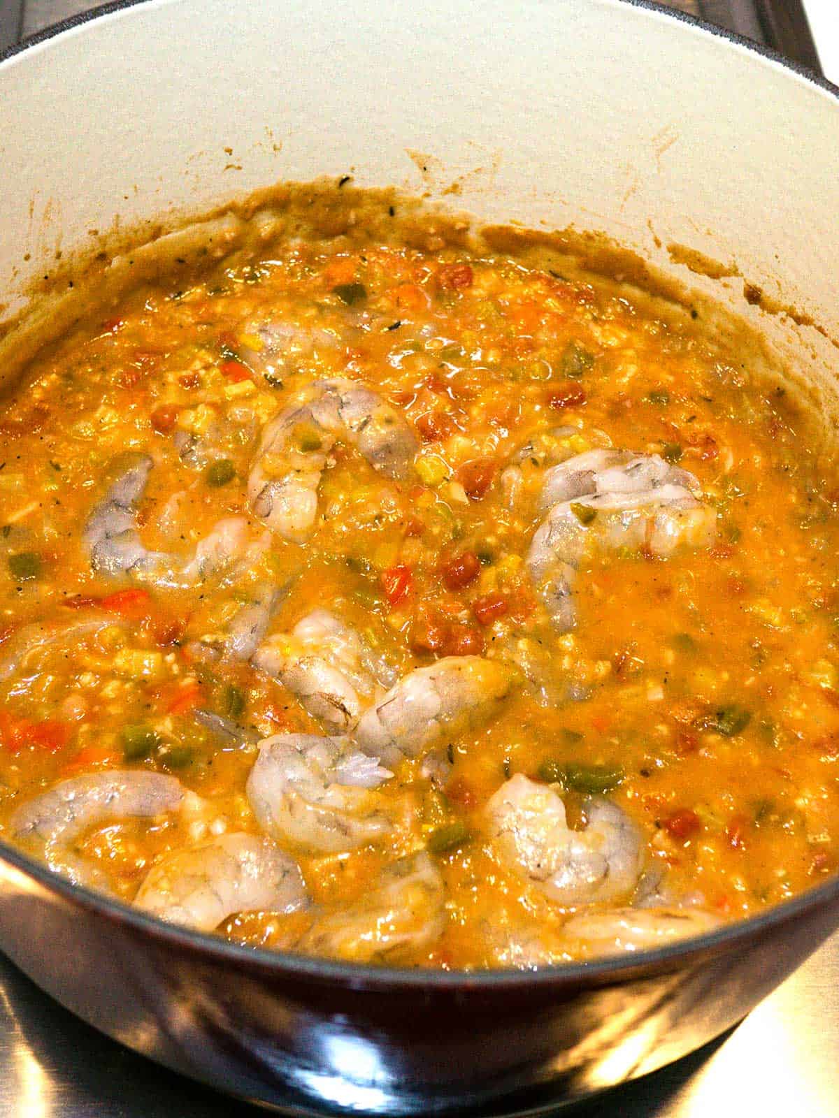 Shrimp added to etouffee mixture in dutch oven.
