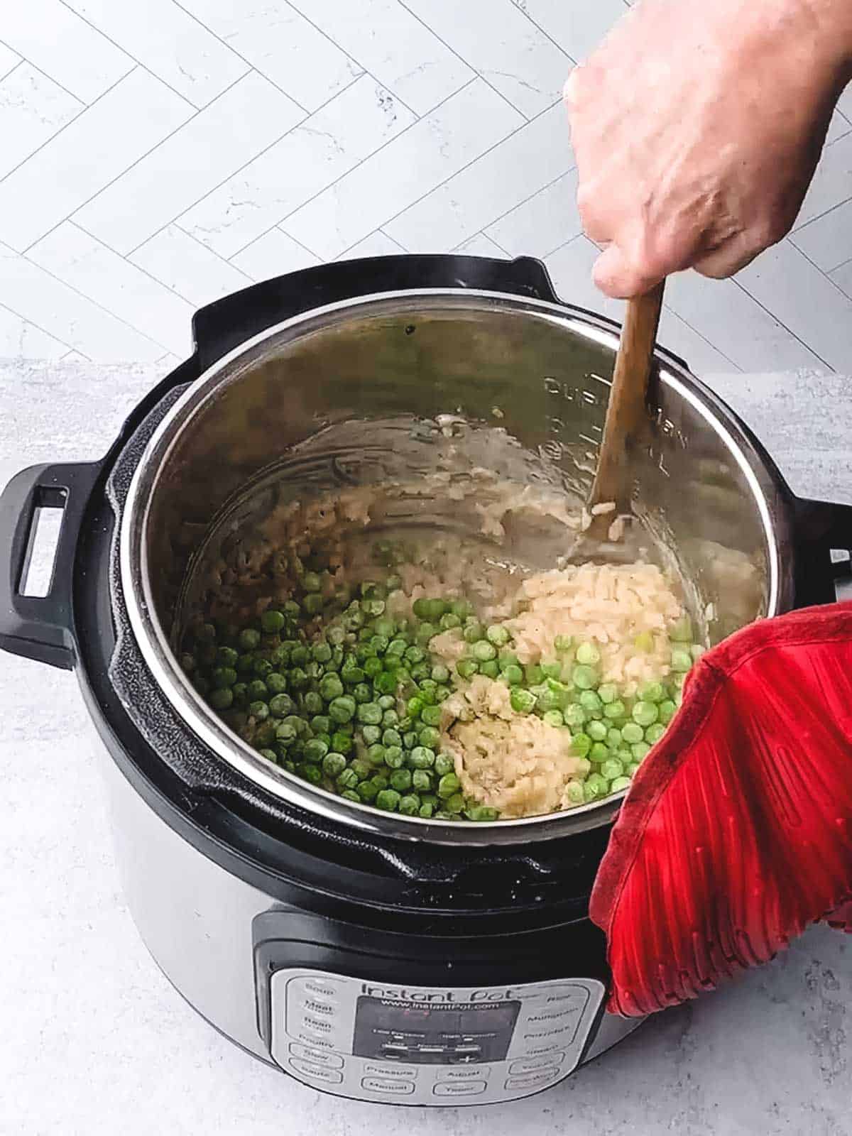 Stirring the green peas in the risotto mixture.