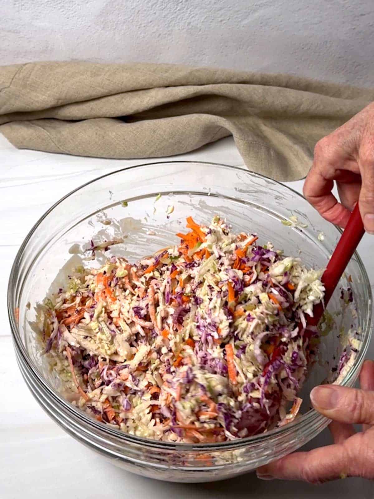 Stirring dressing with the coleslaw.