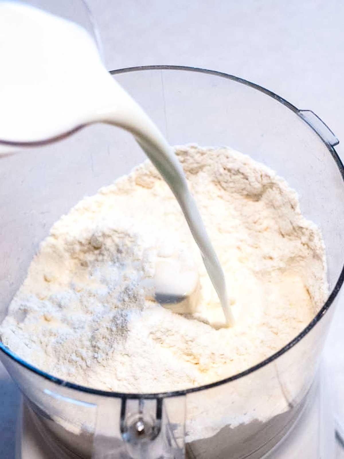 Adding milk to food processor.