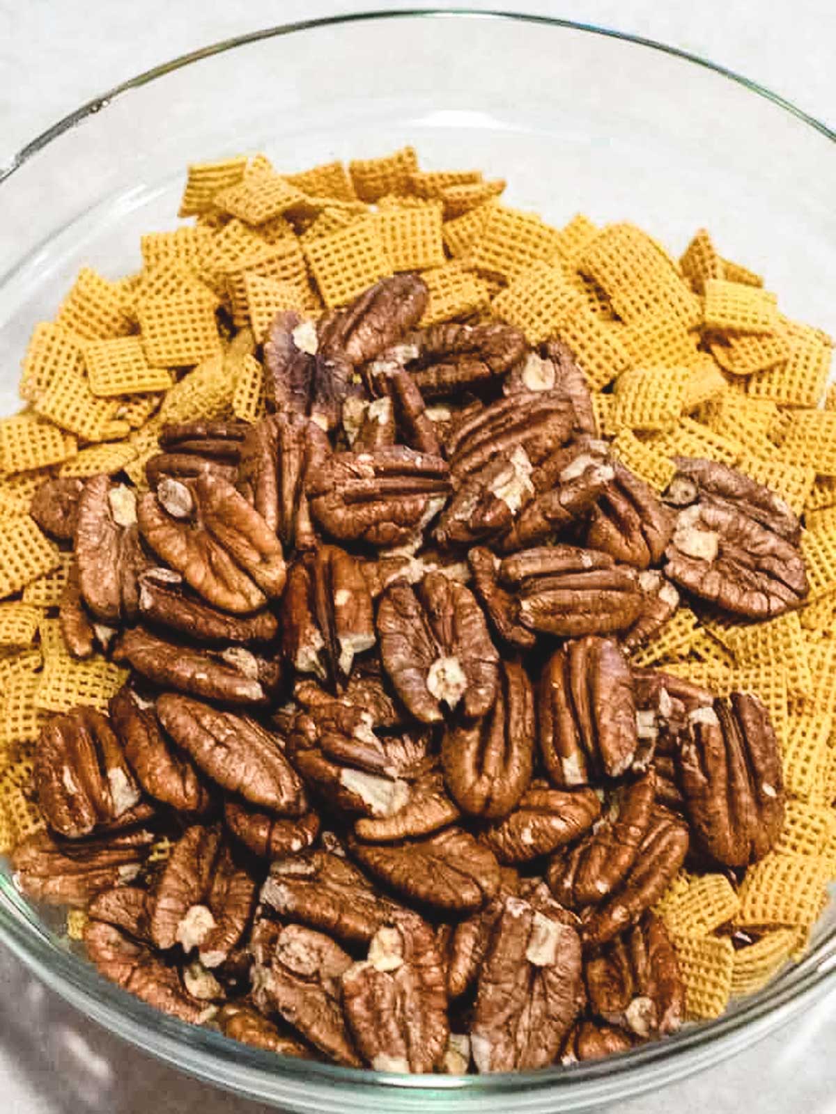 Corn Chex and pecans in bowl.