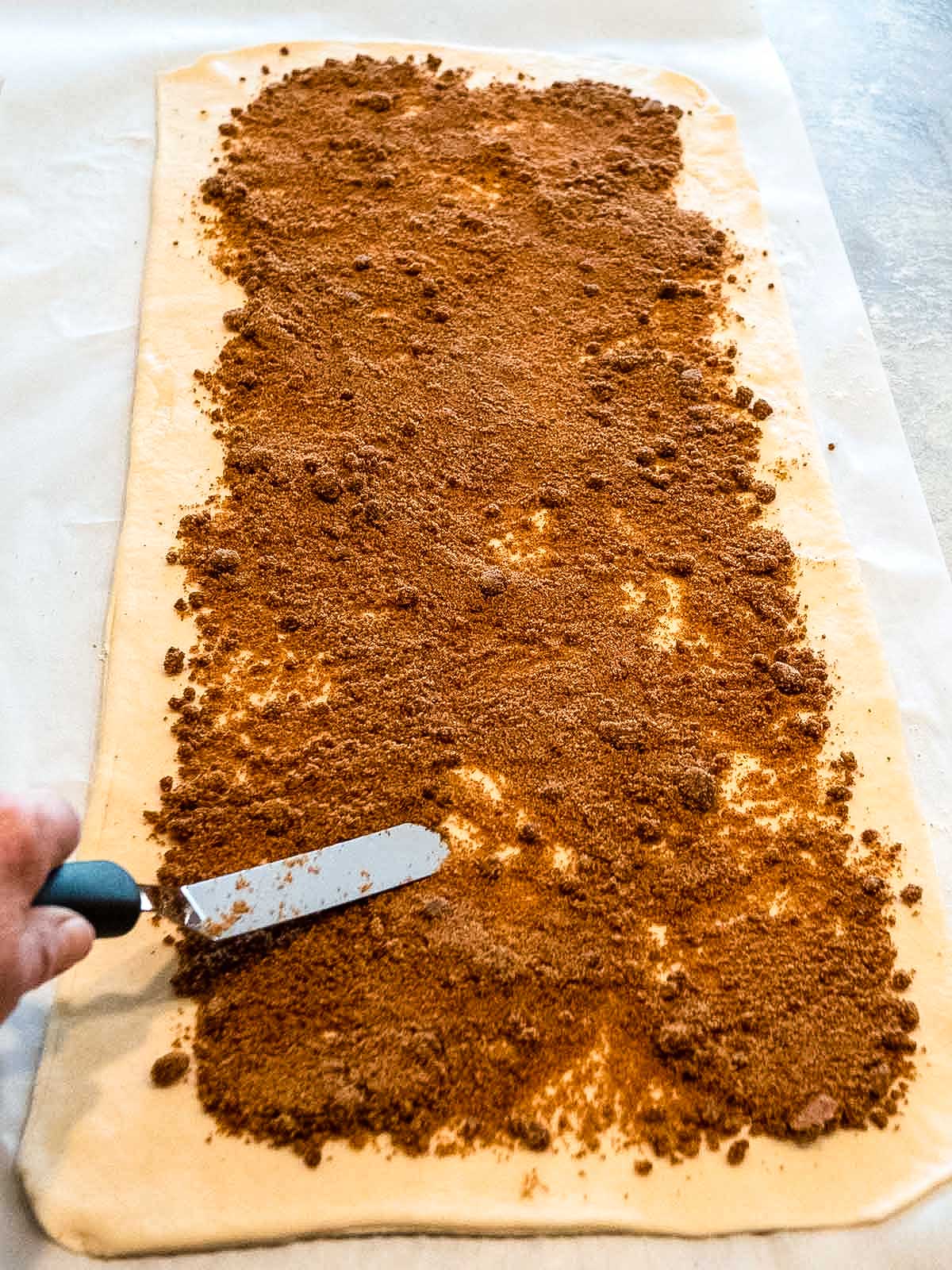 Spreading the Cinnamon filling on the dough.