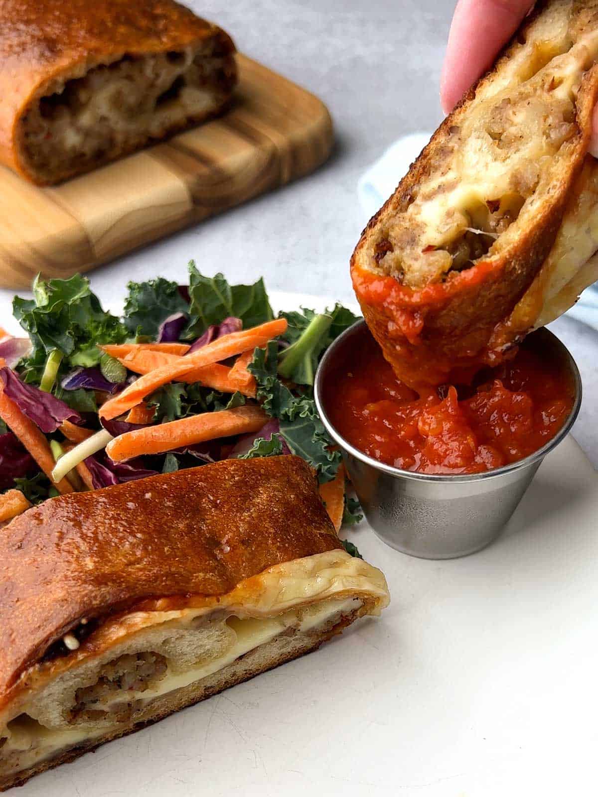 Dipping sausage bread in marinara sauce.