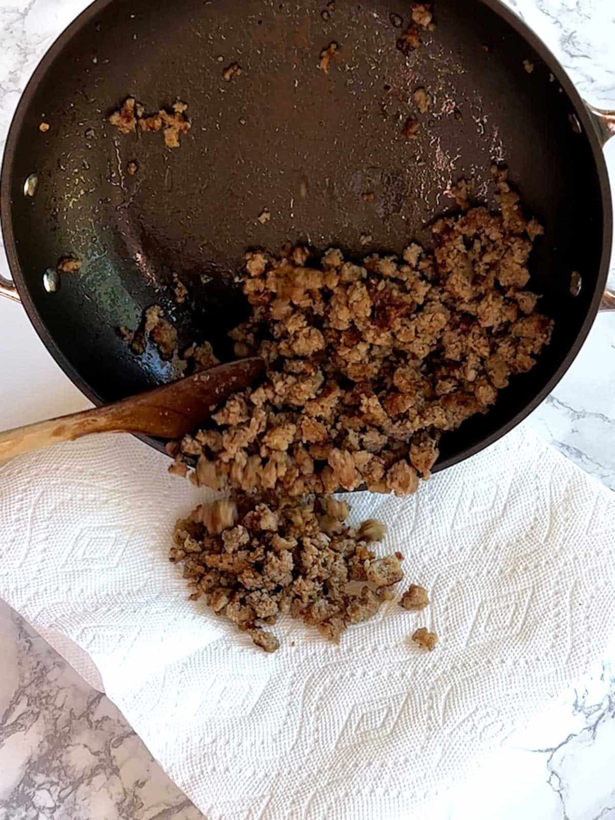 Draining cooked sausage on paper towels.