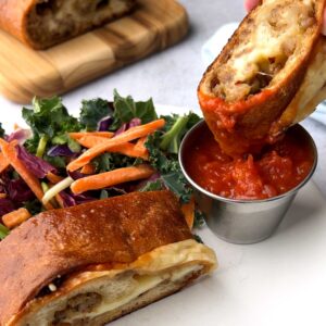 Dipping sausage bread in marinara sauce.