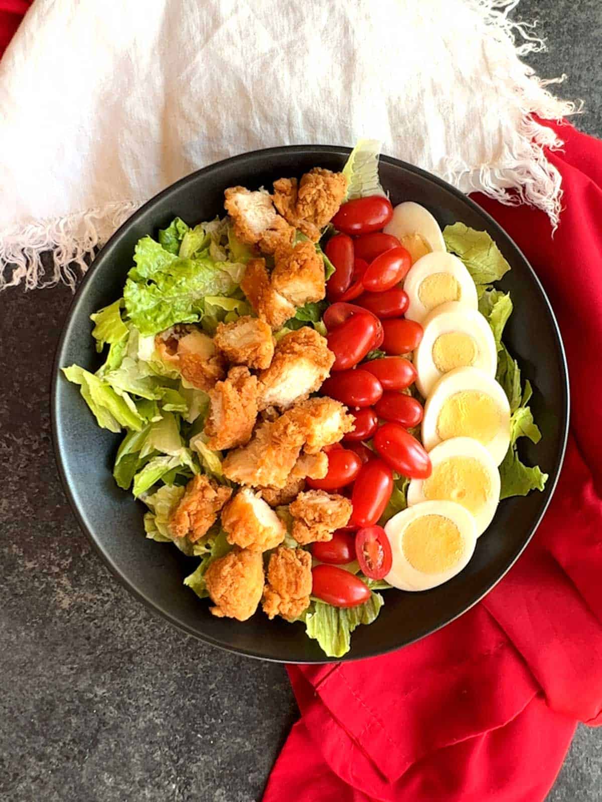 Fried chicken strip cut into pieces added to the salad.