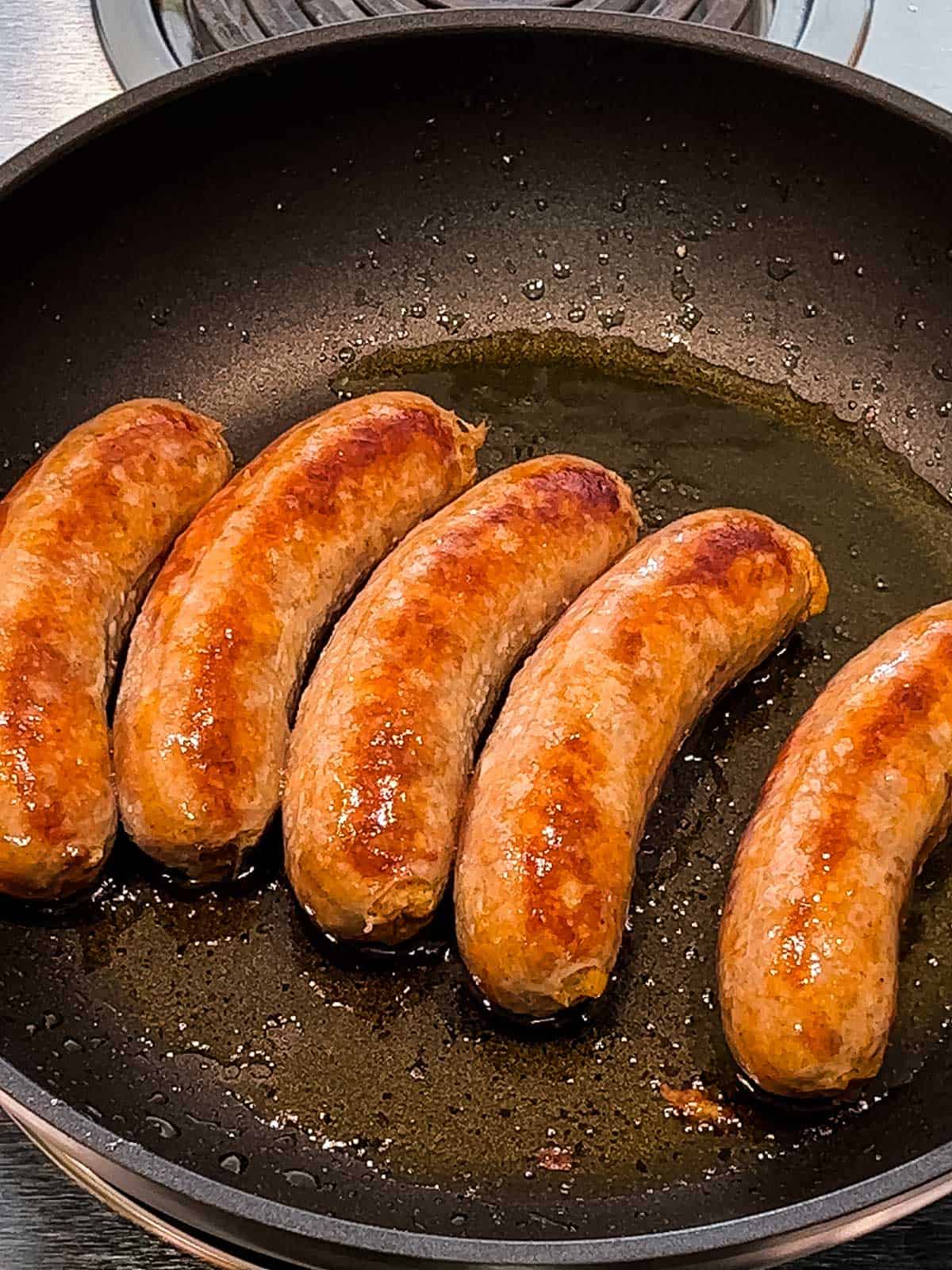 Browning the Italian sausage in a skillet.