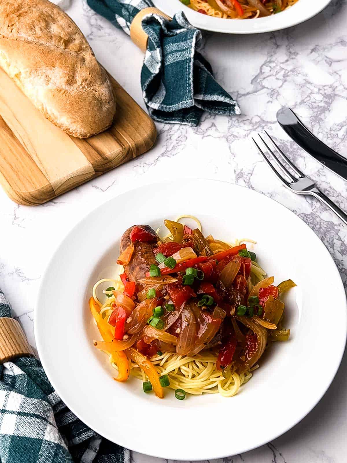 Sausage peppers and onions over pasta.