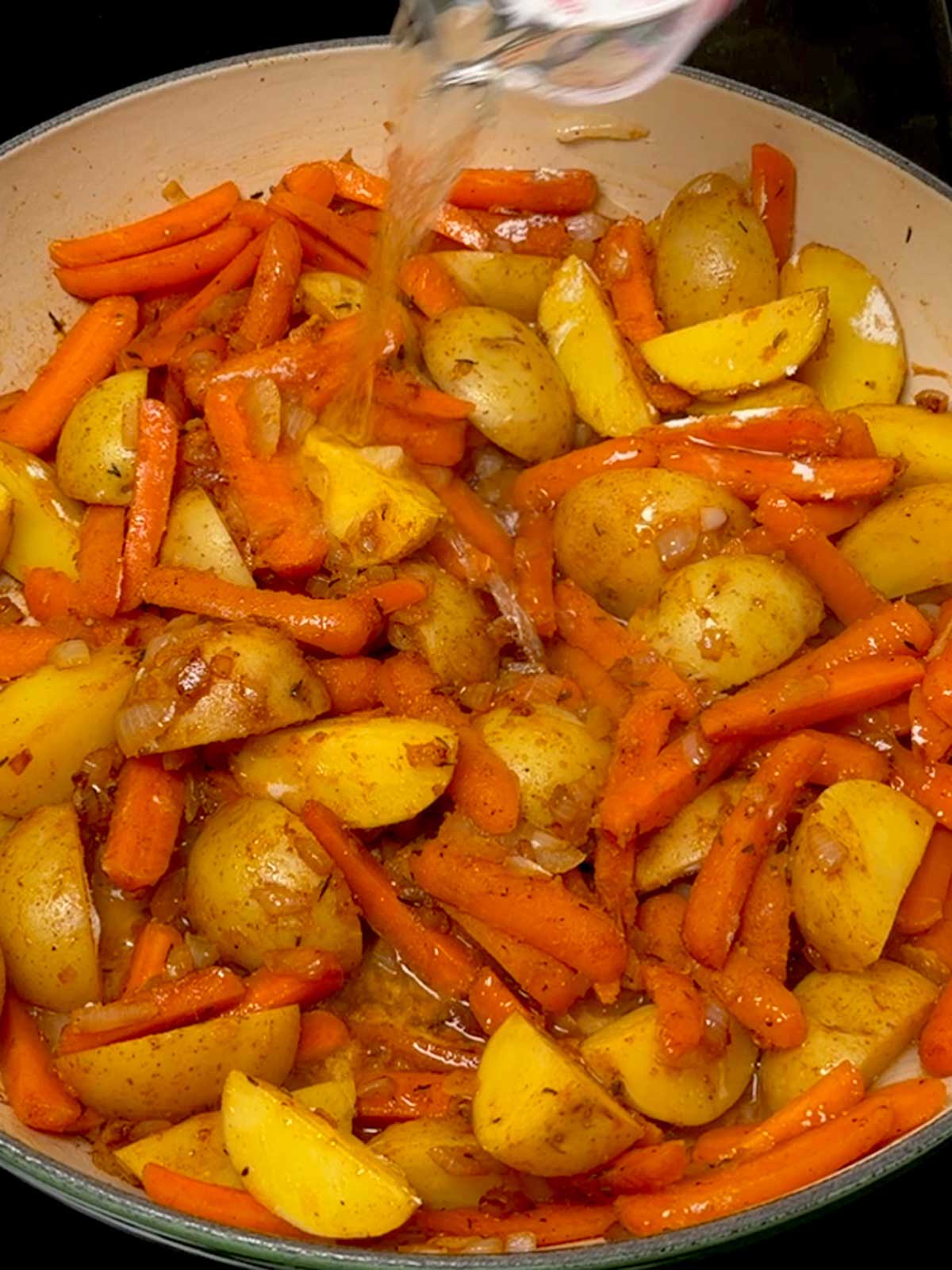 Adding wine to the veggies in the braiser.
