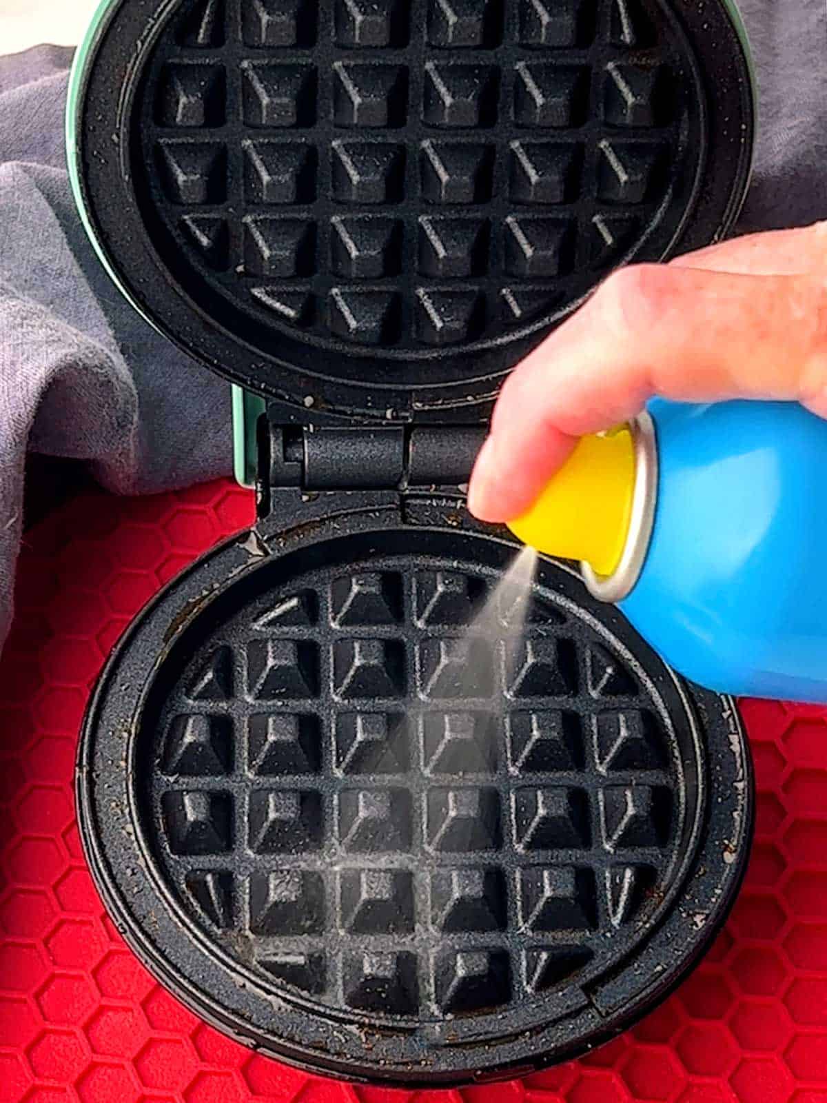 Spraying waffle iron with vegetable spray.