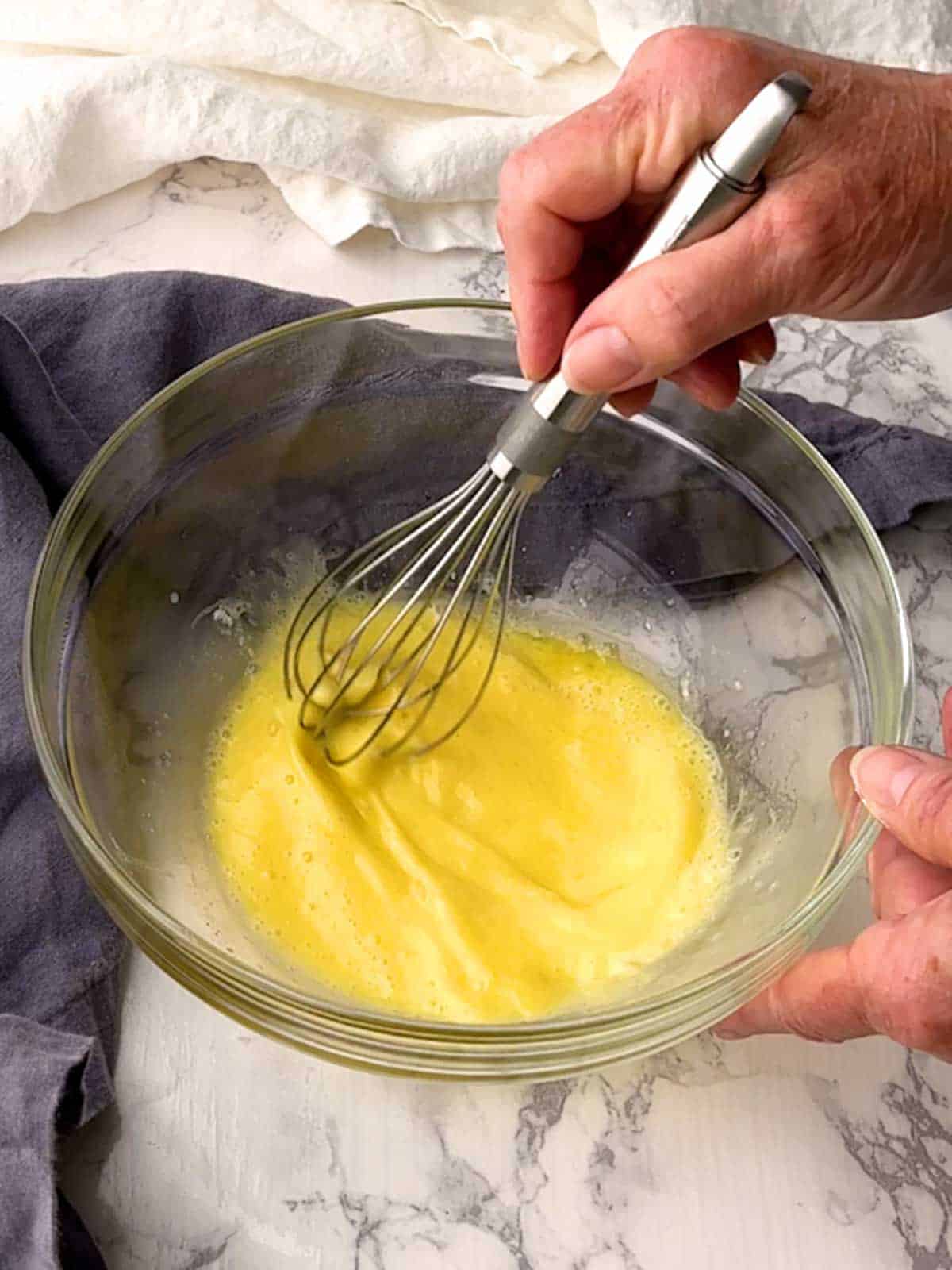 Whisking together milk, melted butter, egg, baking powder and baking soda in a bowl.