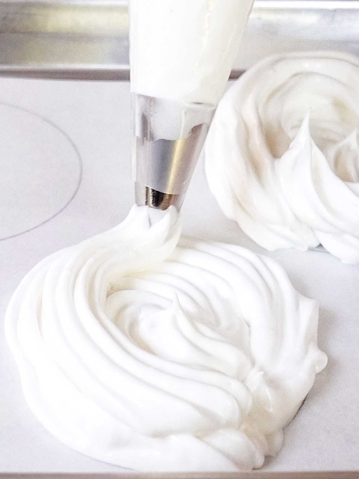 Piping the meringue to form the shells.