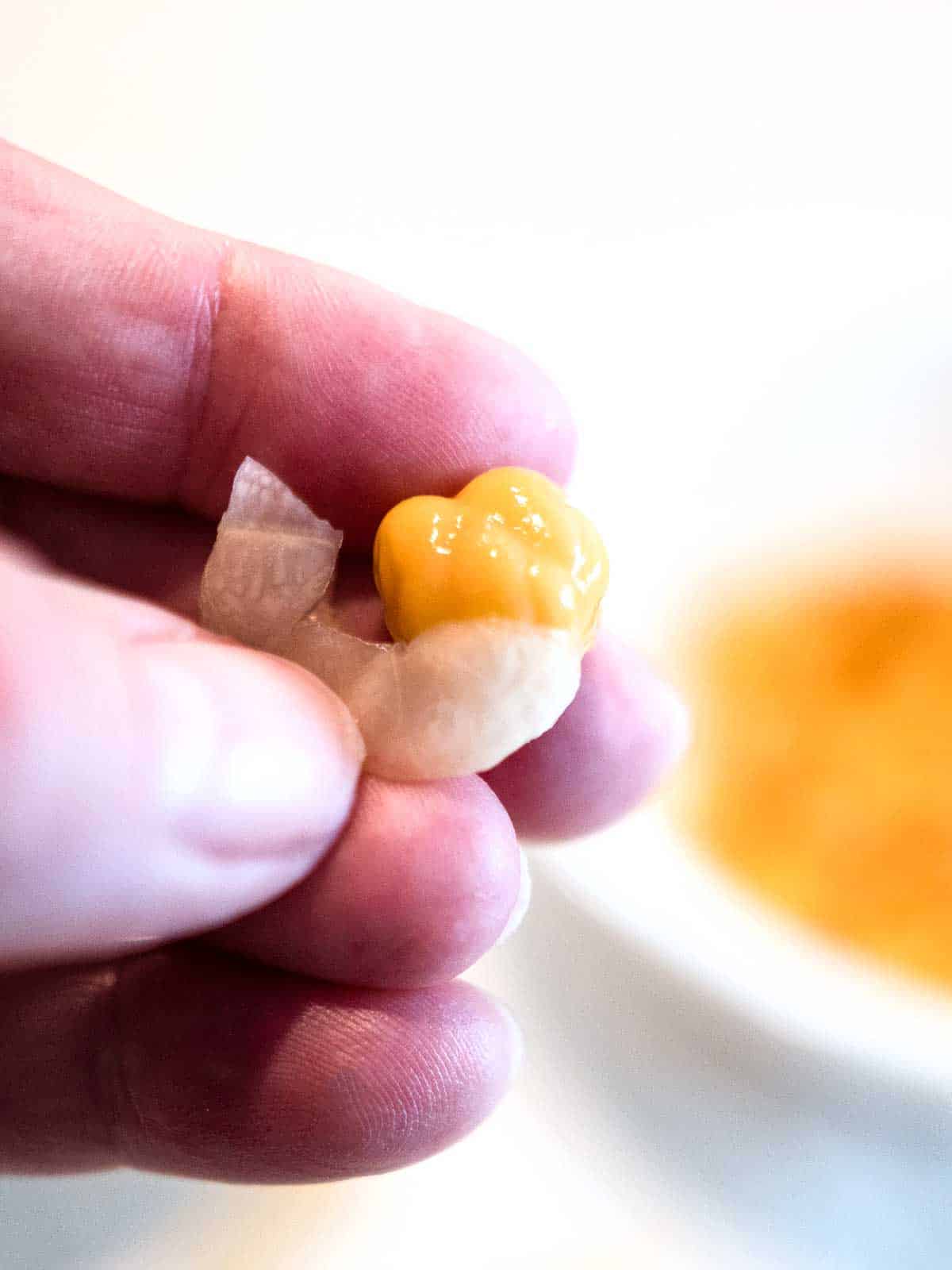 Removing skin from garbanzo bean.