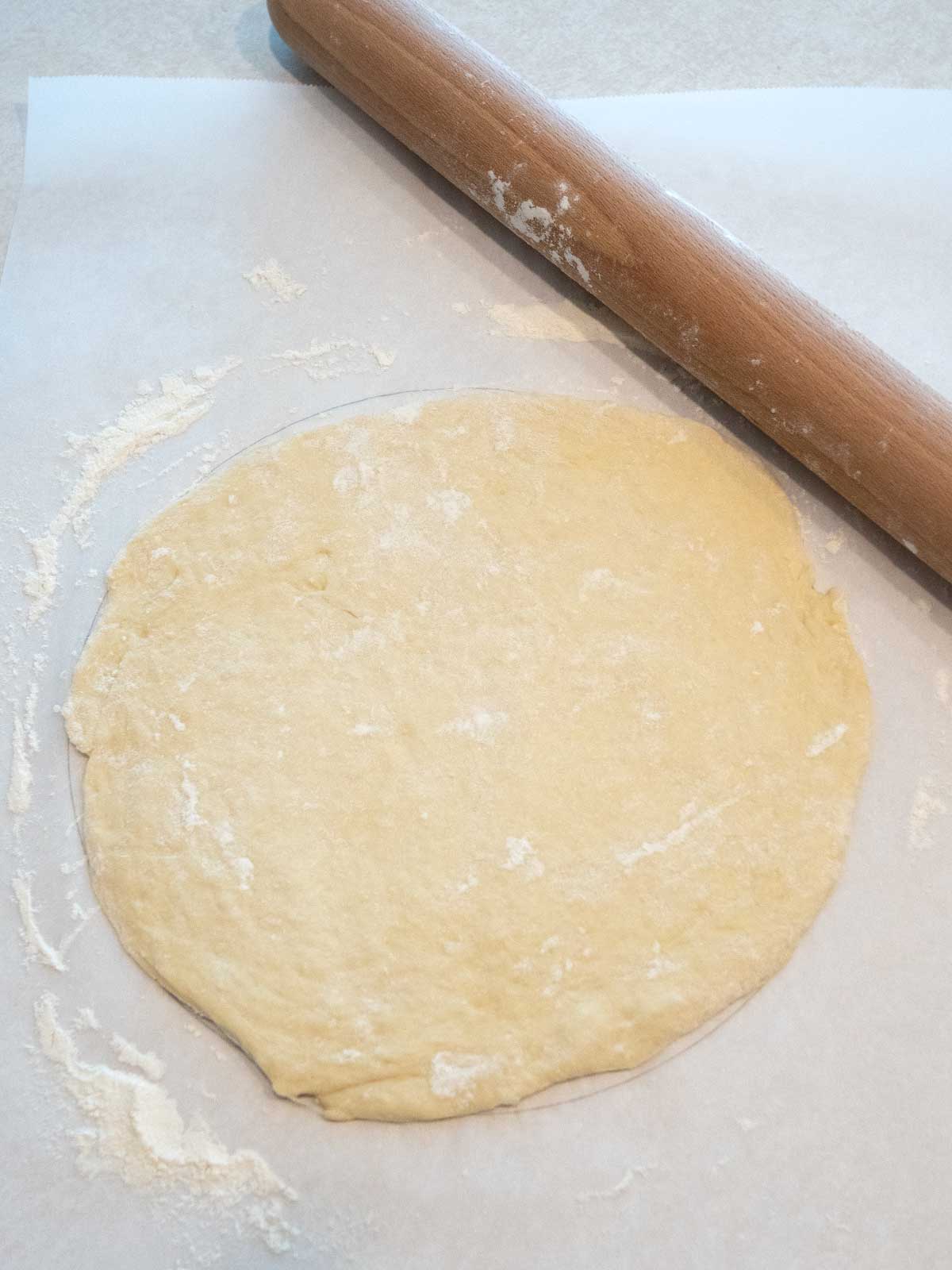 Pizza dough rolled into 11-inch circle.