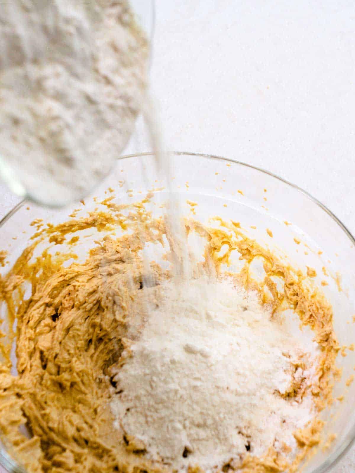 Adding flour for cookie dough.