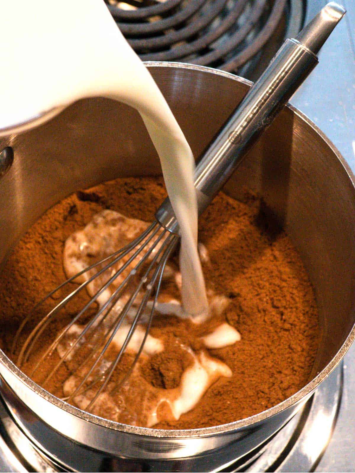 Adding milk to dry ingredients in saucepan.