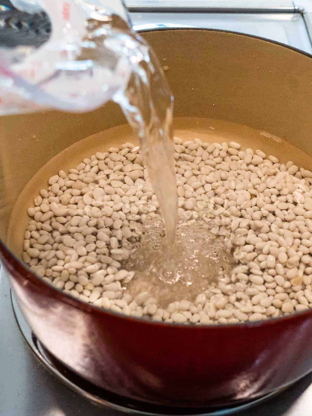 Adding water to dried beans for soaking.