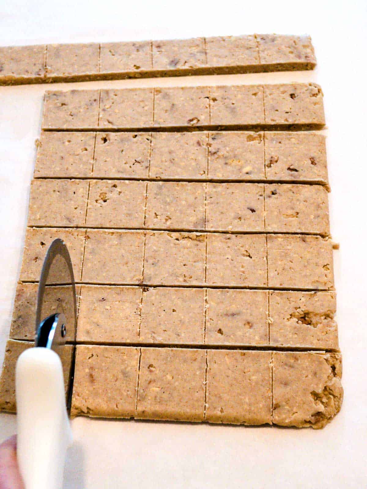 Cutting cookie dough with a pizza cutter.