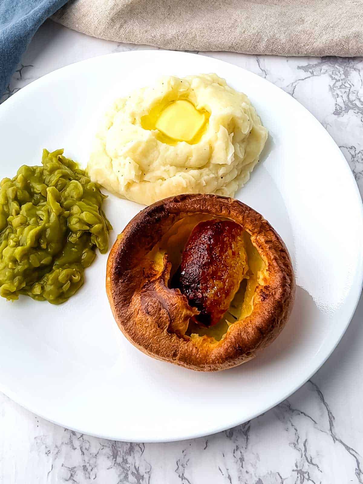 Toad in the Hole with mashed potatoes and mushy peas.