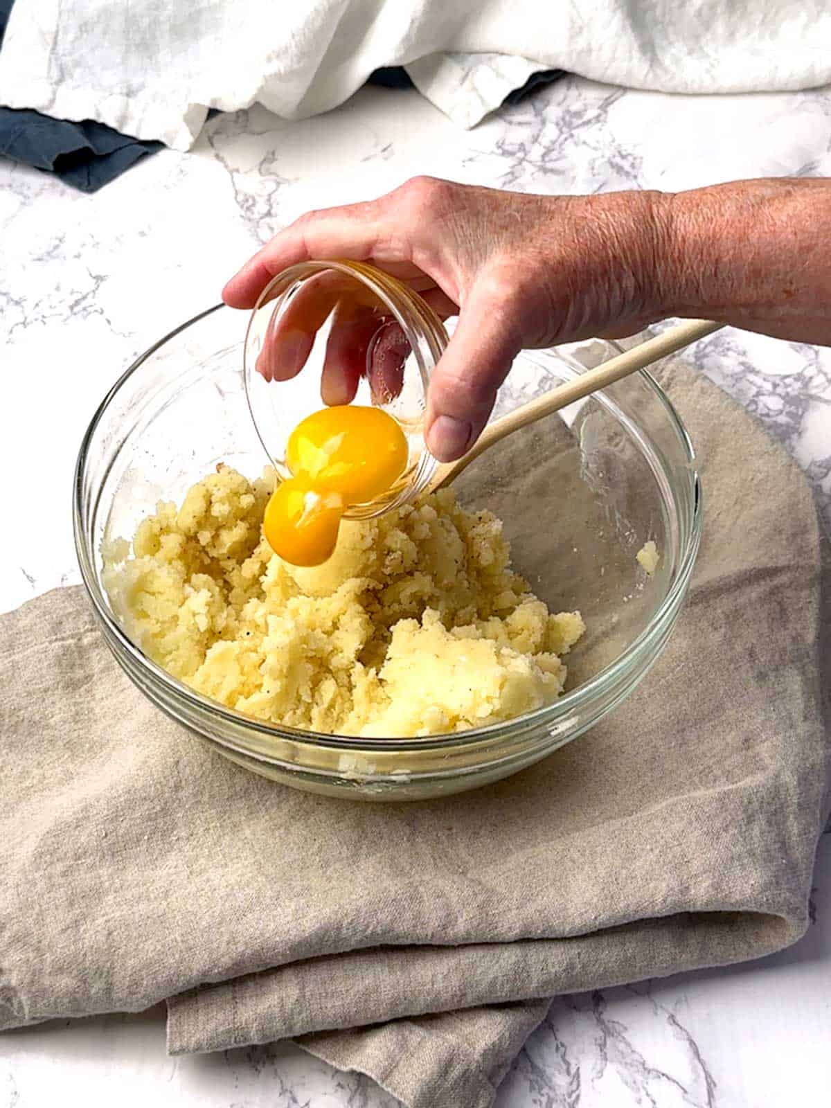 Adding egg yolks to the potato mixture,