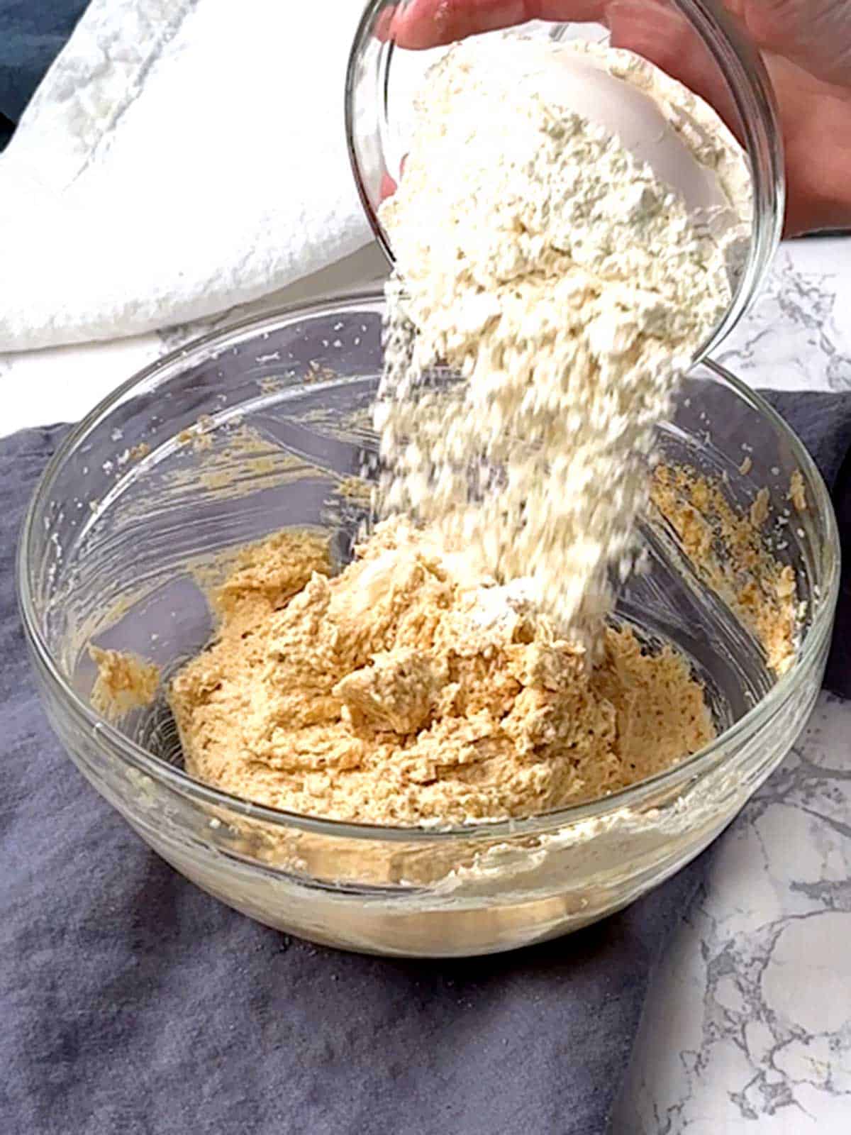 Adding flour to the cookie mixture.