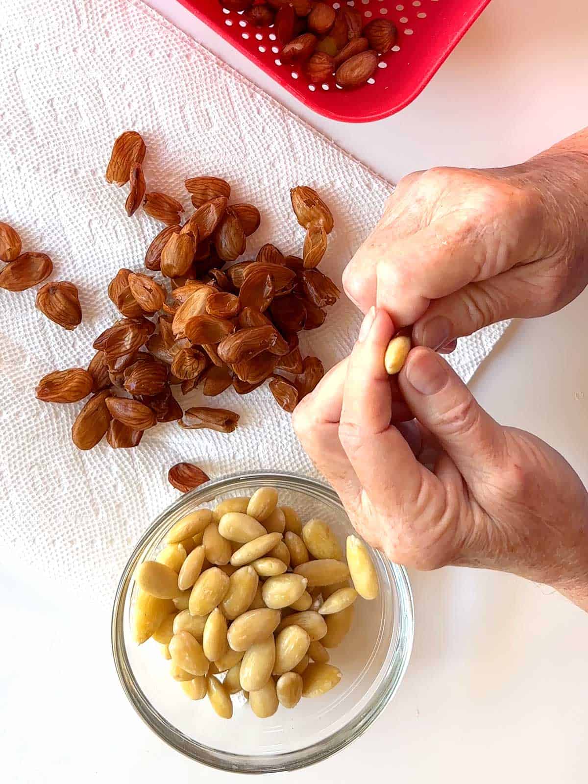 Removing the skins of the almonds.