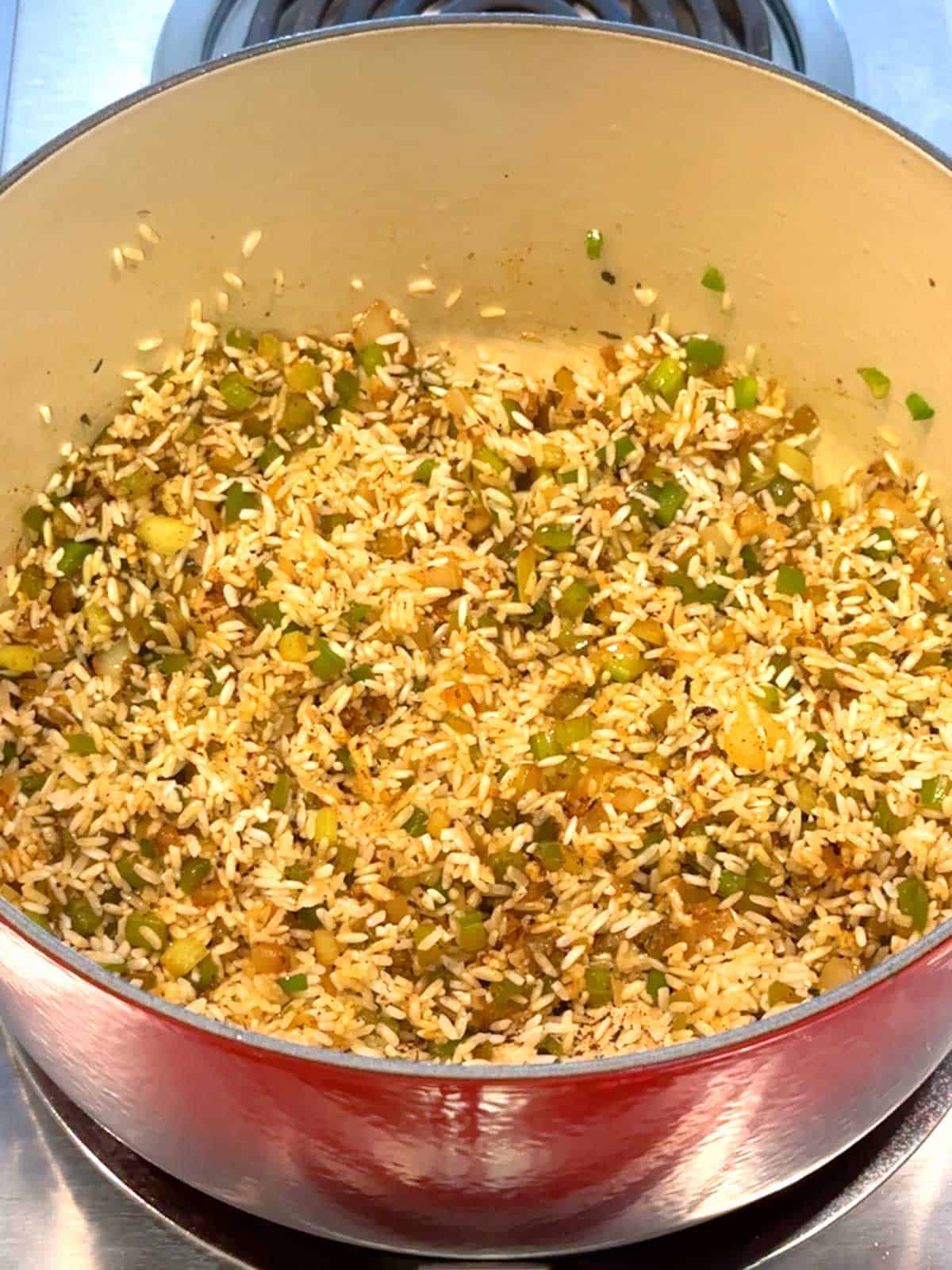 Rice added to Dutch oven with vegetables and spices.