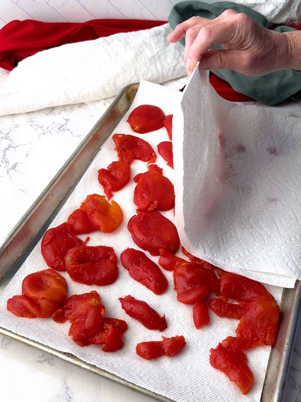 Blotting the tomatoes with a paper towel.