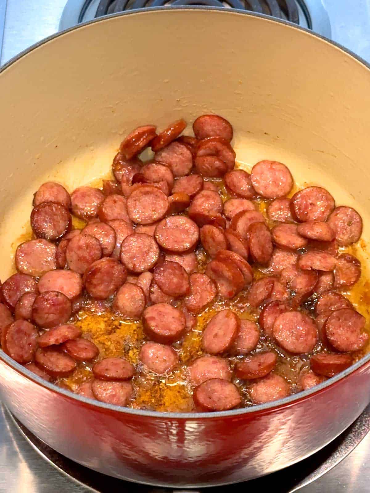 Cooking the smoked sausage in a dutch oven over medium heat.