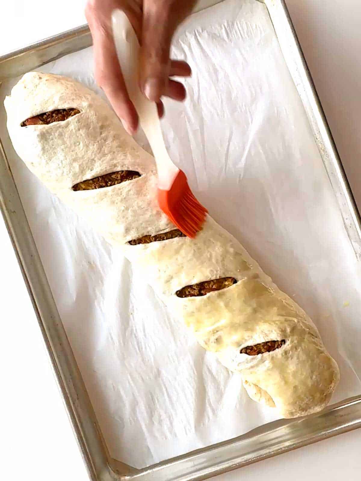 Brushing taco bread with egg wash prior to baking it.