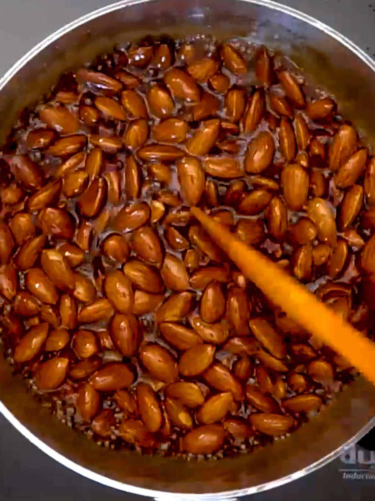 Stirring almonds in syrup with silicone spatula.