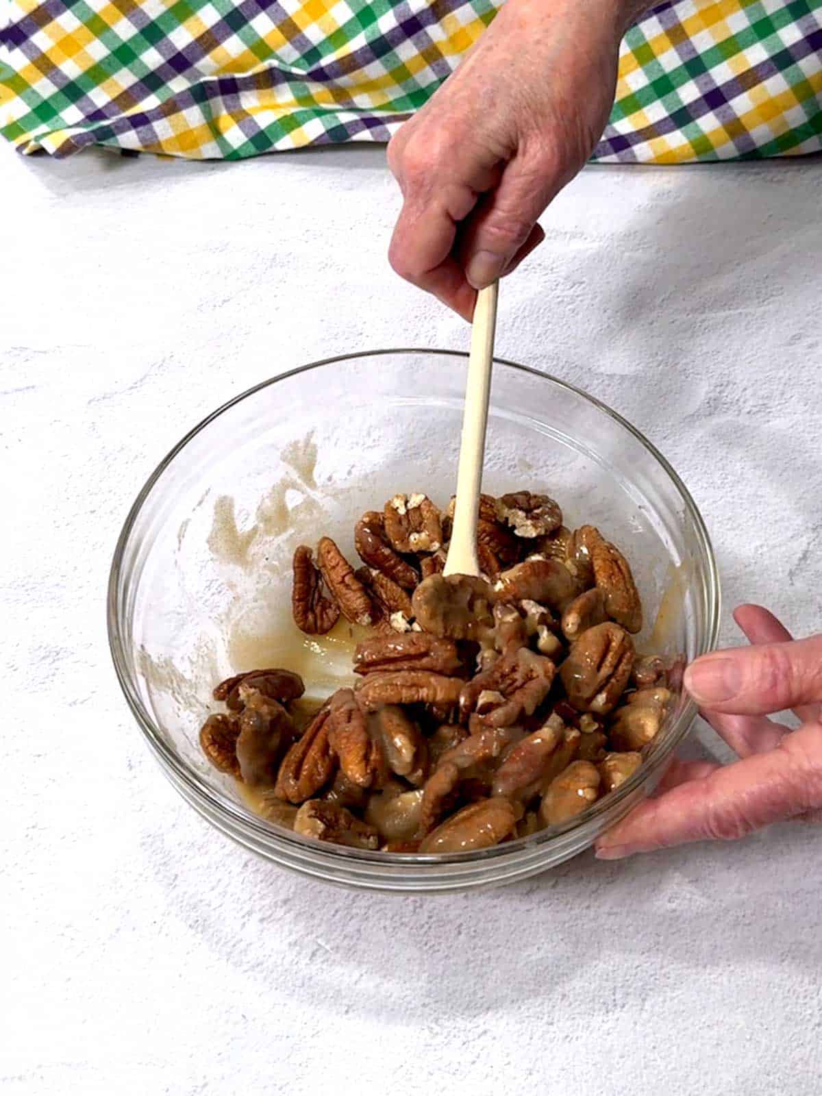 Stirring pecans with the brown sugar/cream mixture.