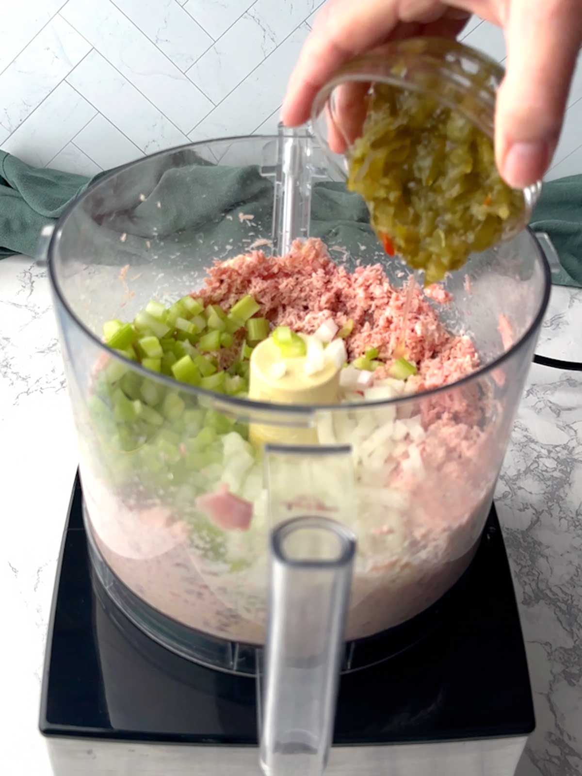 Adding sweet pickle relish to the food processor.